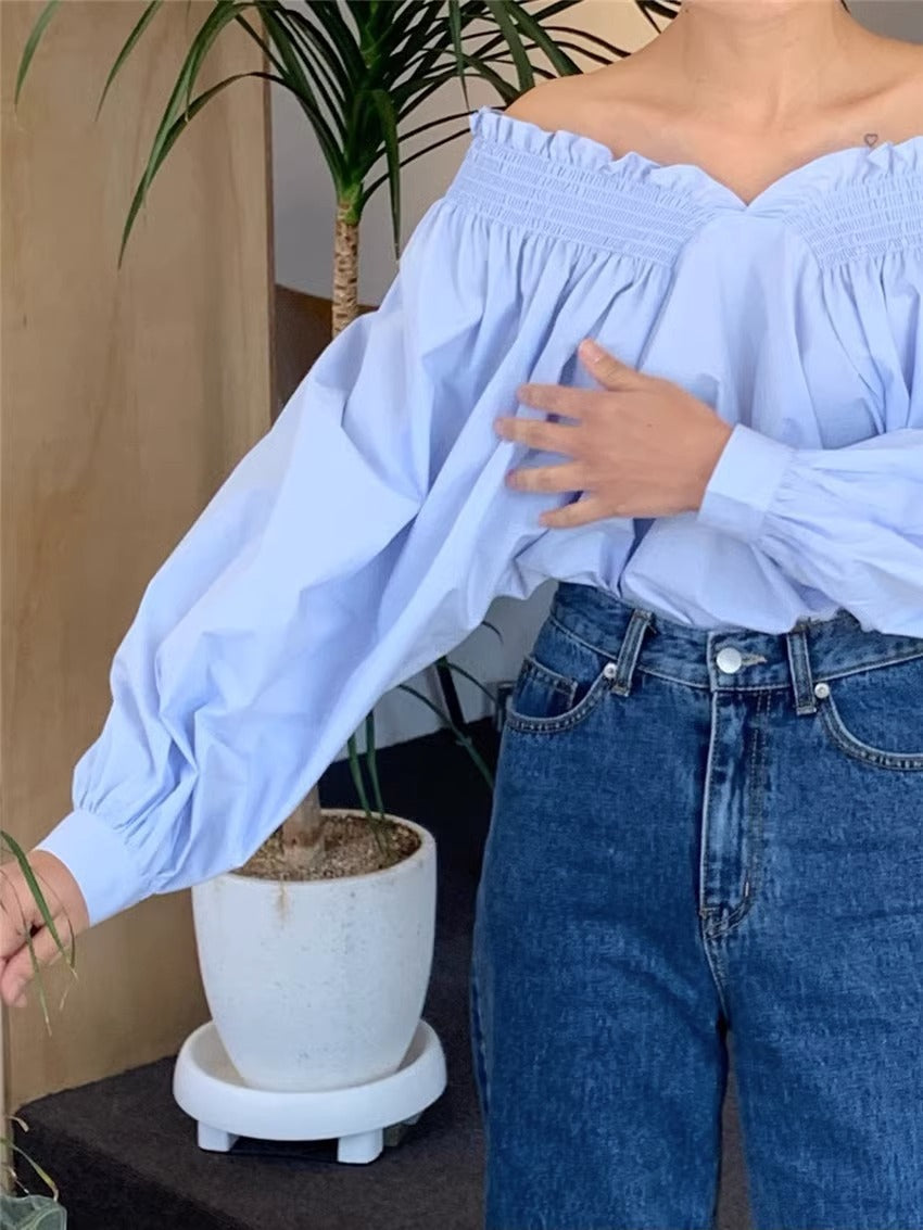 Camisa de mujer con mangas farol invertidas y hombros descubiertos en azul leche y blanco francés